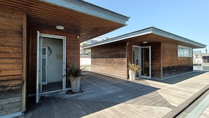 Un edificio moderno con paredes exteriores de madera y un acceso cubierto.