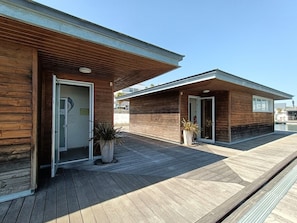 Un bâtiment moderne aux murs extérieurs en bois et doté d’une entrée abritée.