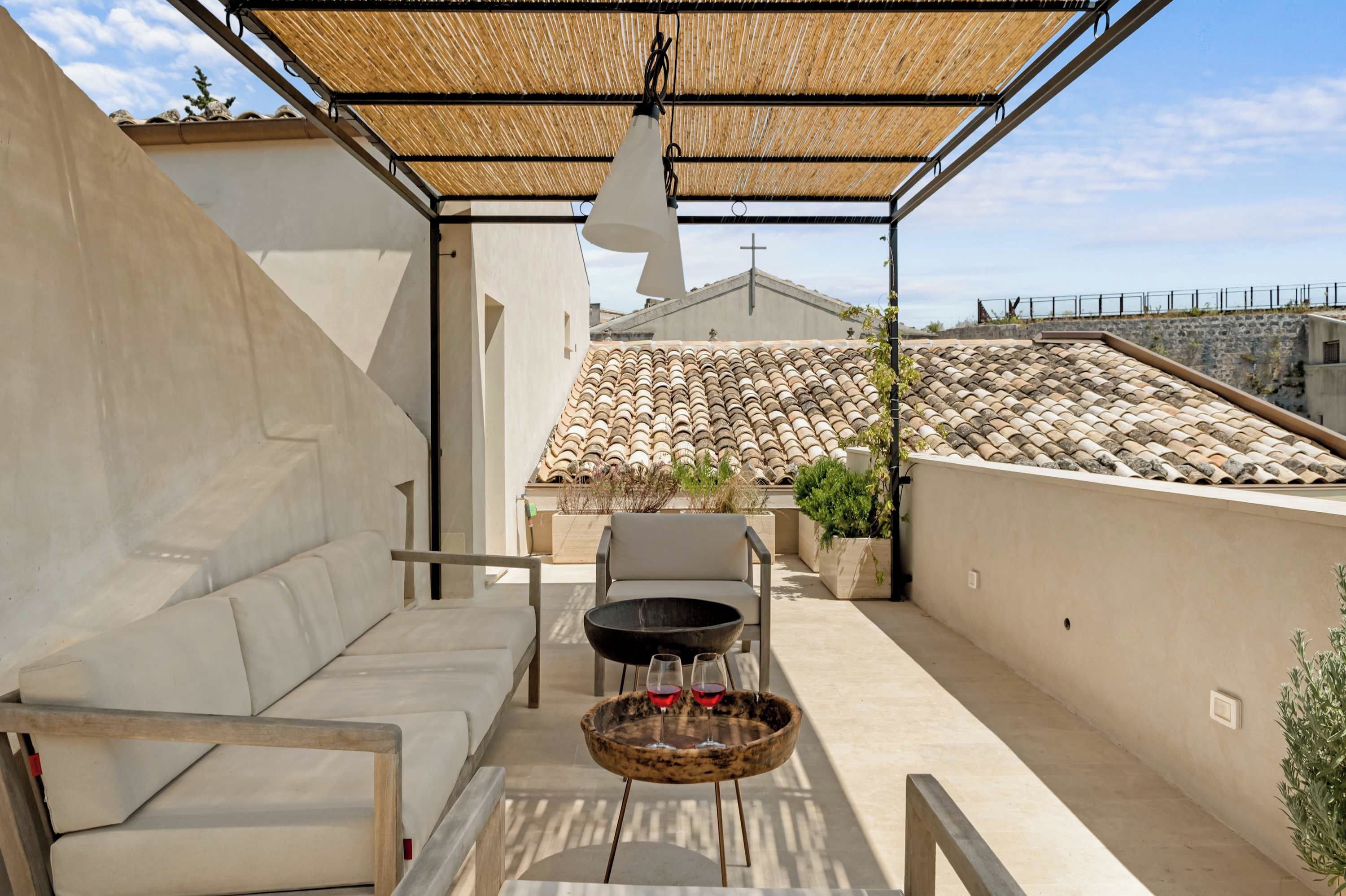 Un patio al aire libre con una mesa, sillas y un colgador de luz.