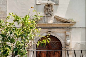 A building facade with a stone archway and a wooden door. - Historic Baroque Palazzo w/Rooftop Terrace, City (Modica)