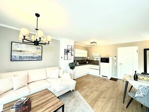 Ein modernes Wohnzimmer mit einer Couch, einem Couchtisch und einem Essbereich mit Tisch und Stühlen.