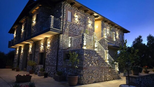 A stone building with multiple balconies and a staircase. - Borgo Caridà - Green Family Holidays (Zaccanopoli)