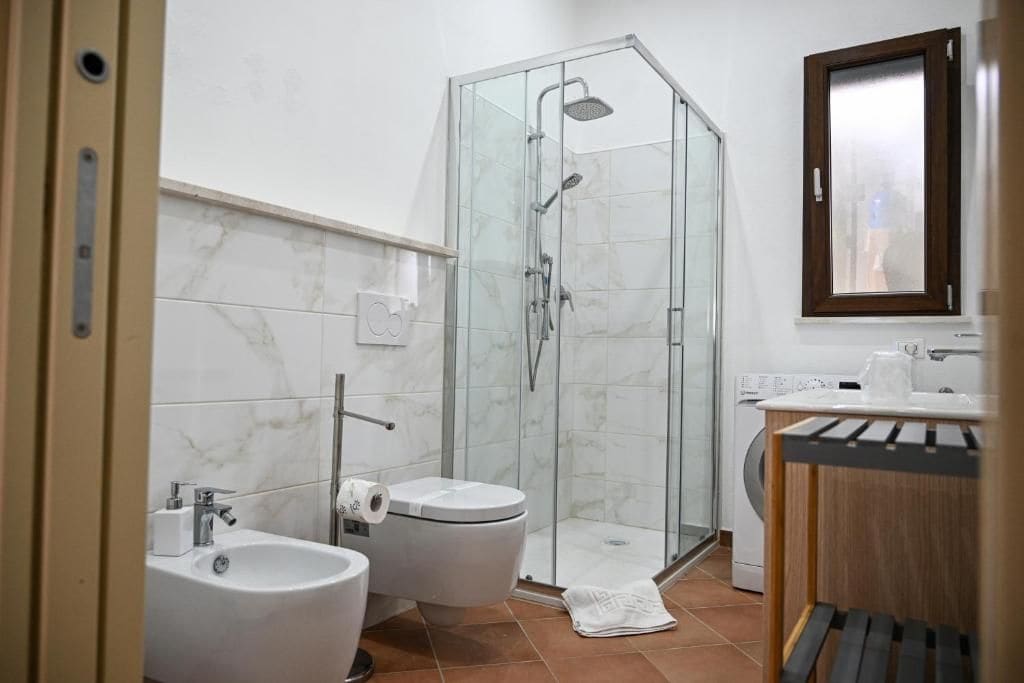 Ein Badezimmer mit Duschkabine, Toilette, Bidet und Waschbecken.