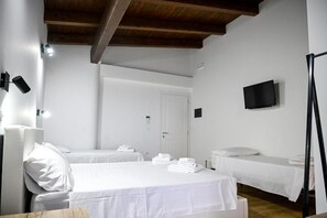 A hotel room with two beds, a television, and a door. - Borgo Caridà - Green Family Holidays (Zaccanopoli)