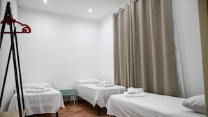 A hotel room with three single beds, a small table, and a red hanger. - Borgo Caridà - Green Family Holidays (Zaccanopoli)