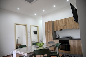 Una cocina moderna con armarios de madera, horno integrado y comedor con mesa y sillas.