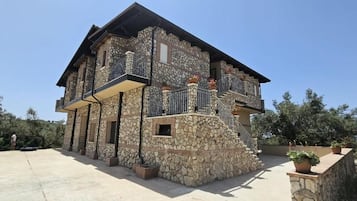 Ein Steinhaus mit Balkon und Treppe.