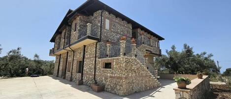 A stone building with a balcony and a staircase.
