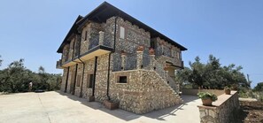 A stone building with a balcony and a staircase.
