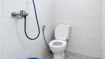 A bathroom with a toilet, a shower, and a blue bucket.