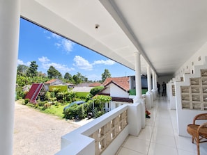 Un espace extérieur abrité offrant une vue sur les maisons et la verdure.