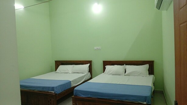 Una habitación con dos camas individuales, cada una con cabecero de madera y edredón azul.