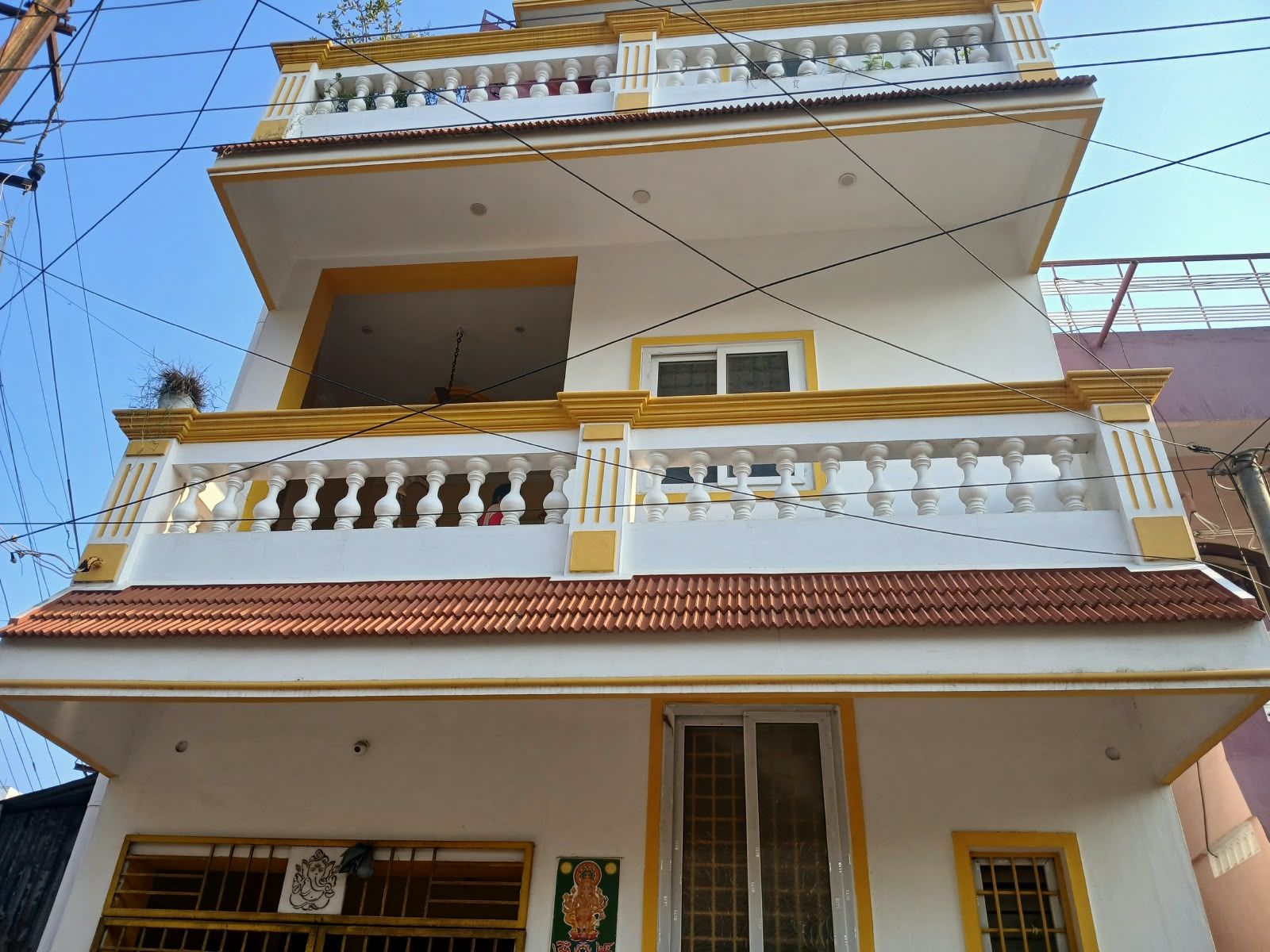 A multi-story building with balconies, a tiled roof, and a window with a decorative frame.