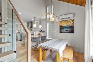 Un interior moderno con comedor, cocina y escalera.