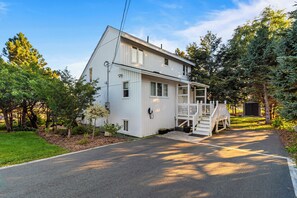 A two-story house with a front porch and a small deck. - Elegant Torbay Ocean View |Fireplace | 3BR Parking (Torbay)