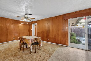 A dining area with a ceiling fan, a table with chairs, and a view through a glass door to the outside. - 3BR Near White Rock Lake - Fire Pit BBQ Grill (Dallas)
