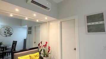 Una sala de estar moderna con un sofá, una planta en maceta y una puerta.