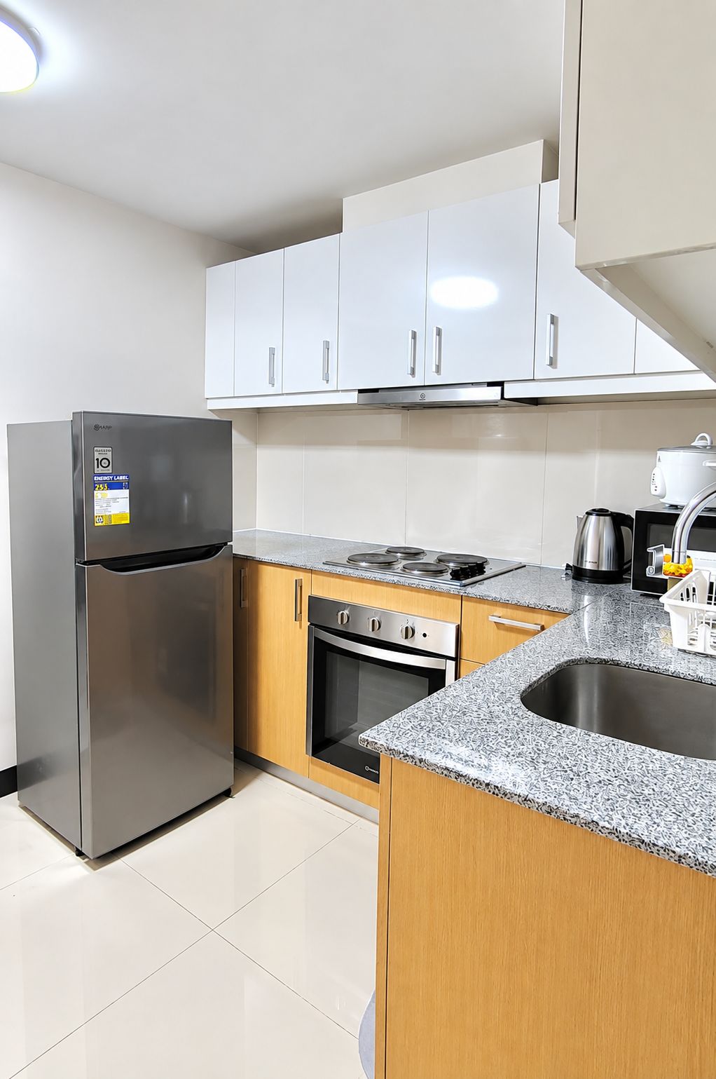 Una cocina moderna con electrodomésticos de acero inoxidable, armarios de madera y encimera de granito.
