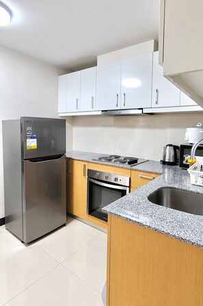 Una cocina moderna con electrodomésticos de acero inoxidable, armarios de madera y encimera de granito.