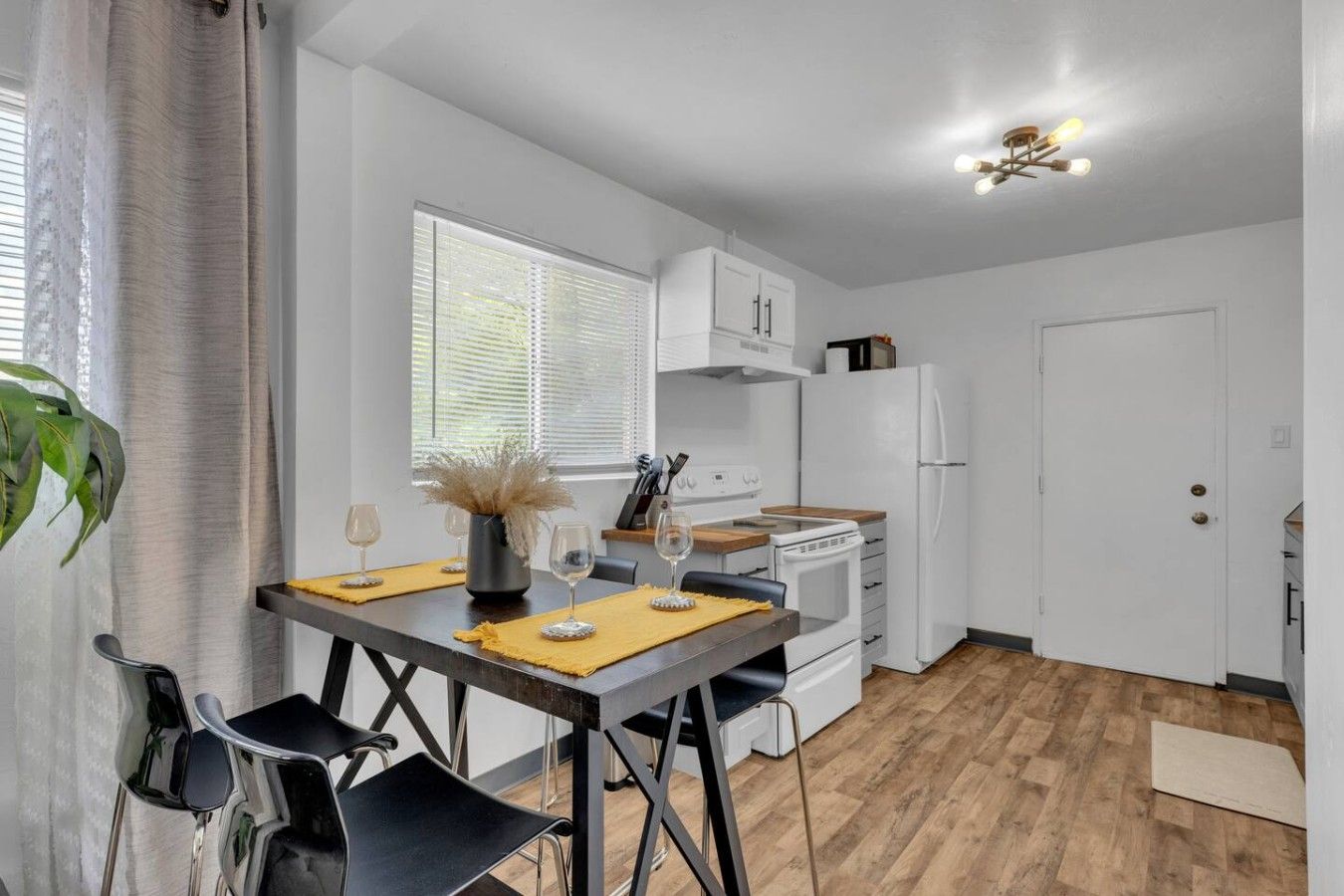 A modern kitchen with white cabinets, a built-in oven, and a white refrigerator.