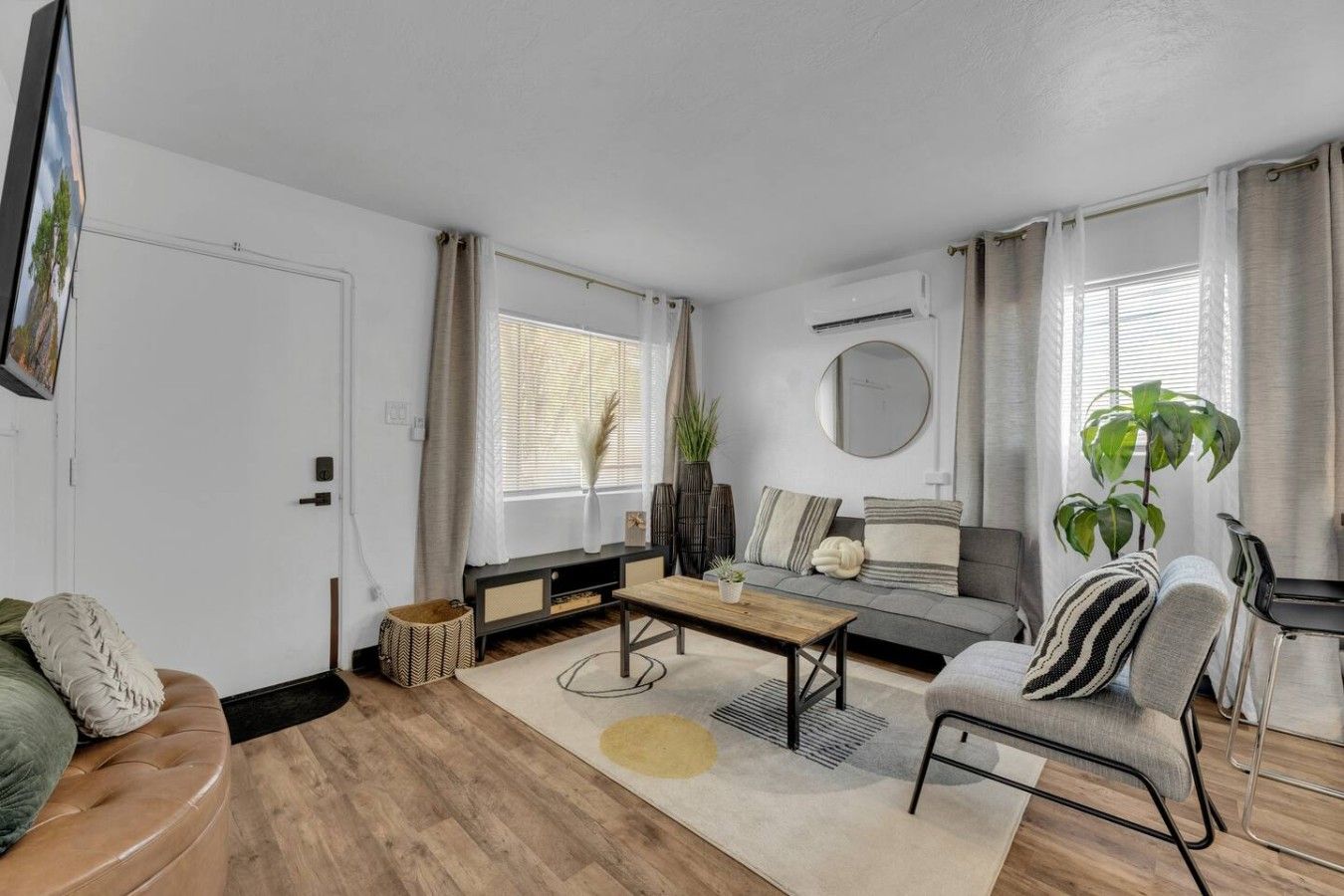 A modern living room with a sofa, coffee table, and a TV mounted on the wall.