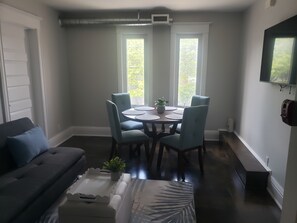 A dining area with a round table, four chairs, and a potted plant. - "Courtyard Arms"  family friendly (Toronto)