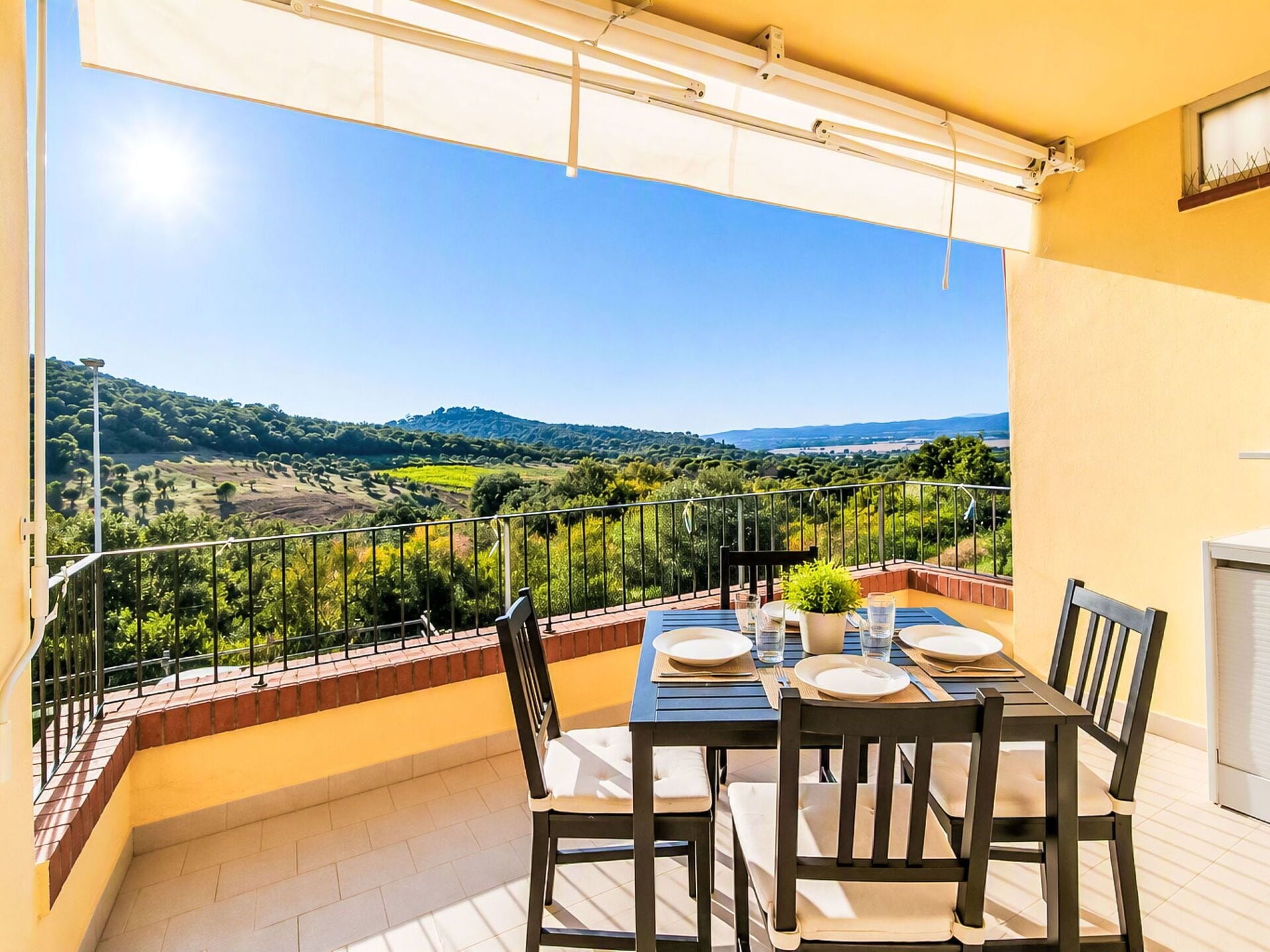 Ein Balkon mit Tisch für zwei Personen, mit Blick auf eine reizvolle Landschaft.