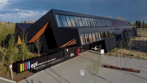 Un bâtiment moderne doté d’un toit en pente et de grandes fenêtres, identifié comme la bibliothèque publique d’Edmonton.