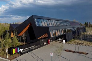 Un bâtiment moderne doté d’un toit en pente et de grandes fenêtres, identifié comme la bibliothèque publique d’Edmonton.