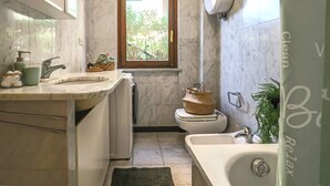 Une petite salle de bain comprenant des toilettes, un lavabo et une baignoire.
