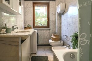 Un baño pequeño con inodoro, lavamanos y bañera.