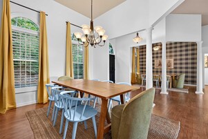 A dining area with a wooden table, blue chairs, and a chandelier.