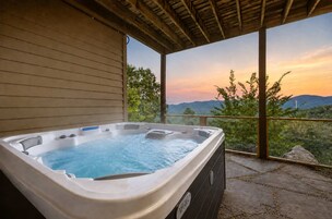 Un jacuzzi con vistas a las montañas al atardecer.