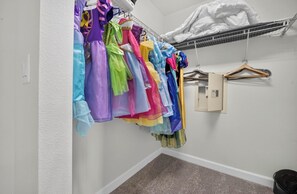 A closet with multiple colorful dresses hanging on a rack. - Low-Tox Theme Park Retreat • 2 Private Theaters (Four Corners)