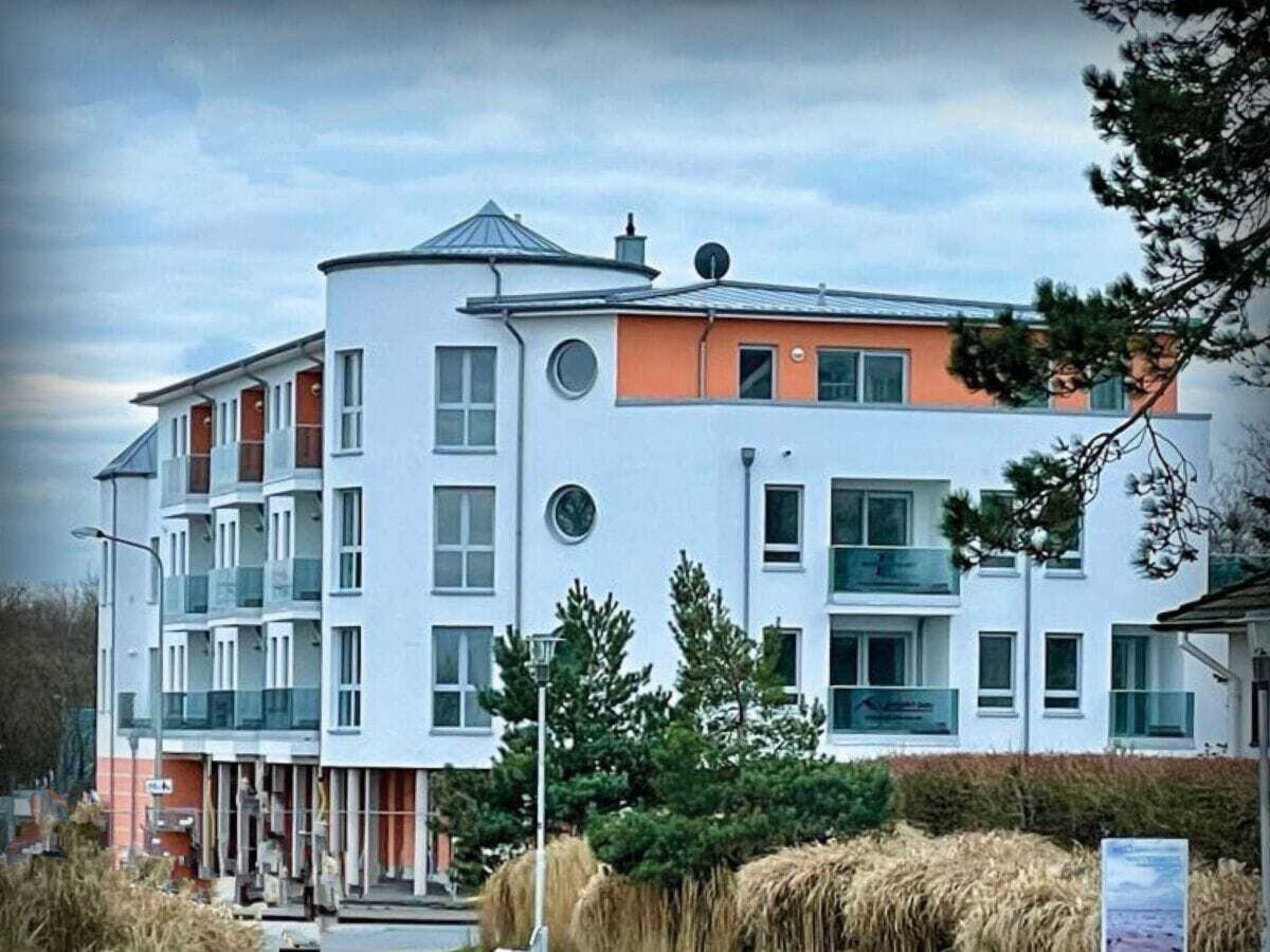 Ein mehrgeschossiges Gebäude mit flachem Dach, großen Fenstern und einem gut sichtbaren Eingang.