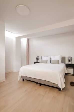 A modern bedroom with a large bed, bedside tables, and a ceiling light. - Spacious Duplex in Centre With Free Parking (Rotterdam)