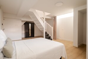 A bedroom with a bed, a staircase, and a door leading to another room. - Spacious Duplex in Centre With Free Parking (Rotterdam)