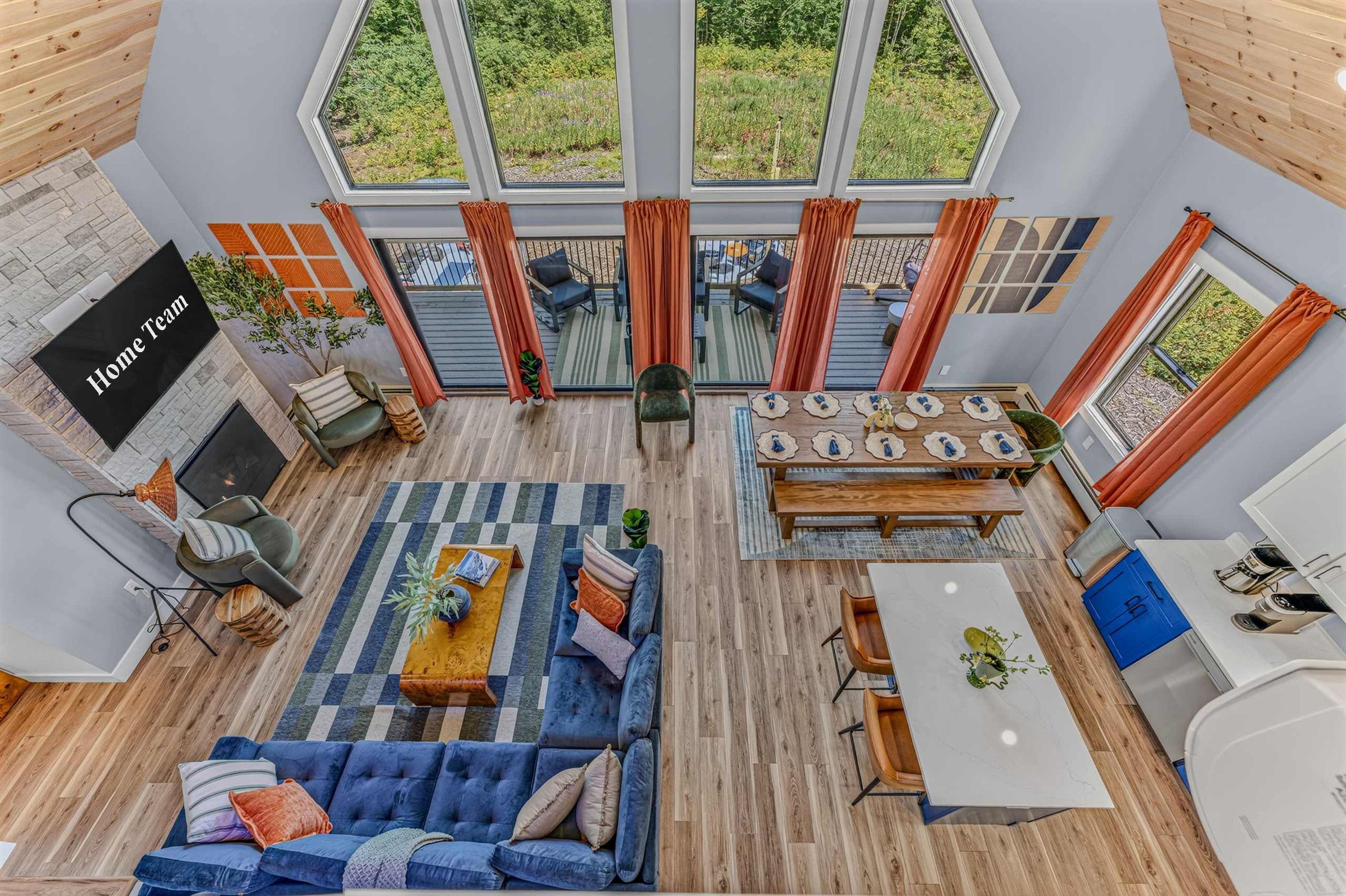 A spacious living area with a blue sofa, a dining table, and a kitchen area with a white countertop.