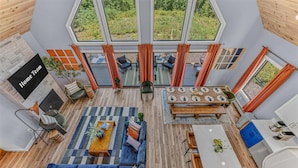 Een ruime woonkamer met een blauwe bank, een eettafel en een keuken met een wit aanrecht.