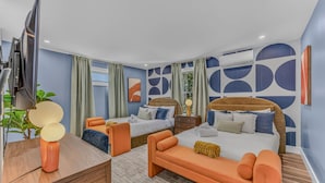 Een moderne hotelkamer met twee bedden, een bureau en een televisie.