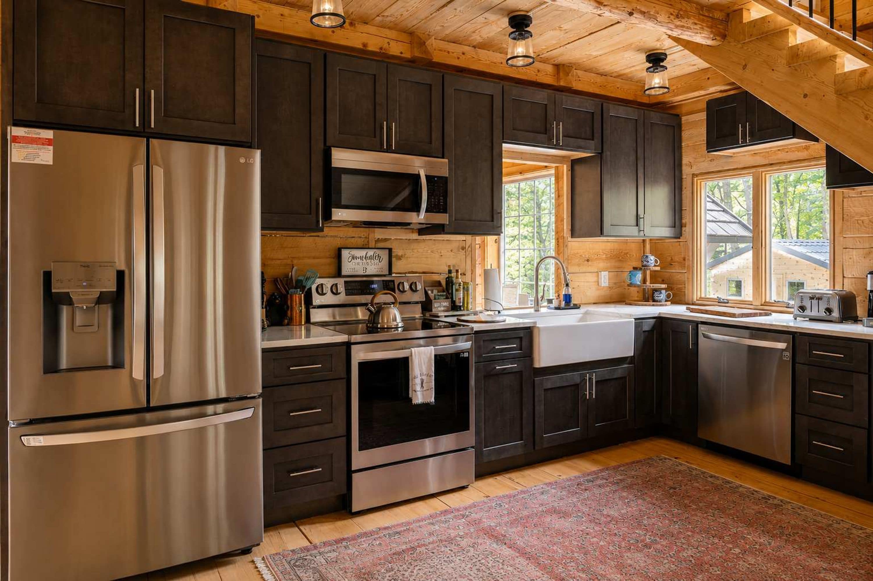 Una cocina moderna con electrodomésticos de acero inoxidable, armarios de madera y un amplio ventanal que proporciona luz natural.