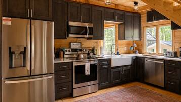 Una cocina moderna con electrodomésticos de acero inoxidable, armarios de madera y un amplio ventanal que proporciona luz natural.