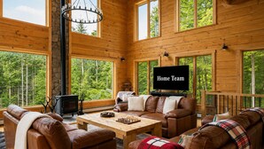 Amplia sala de estar con chimenea, sofás de cuero, una mesa de centro y un televisor que dice 'Home Team'.