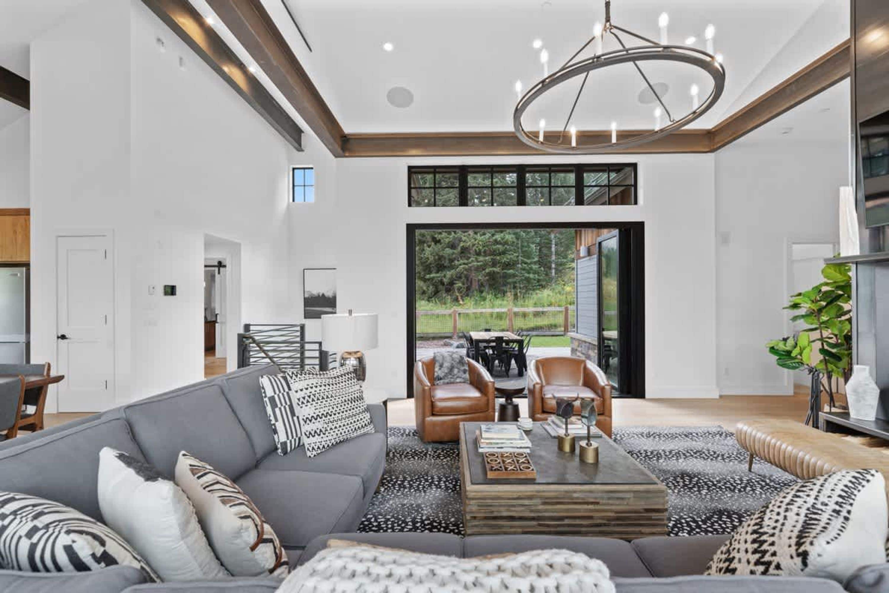 A modern living room with a sectional sofa, a coffee table, and a dining area with chairs.