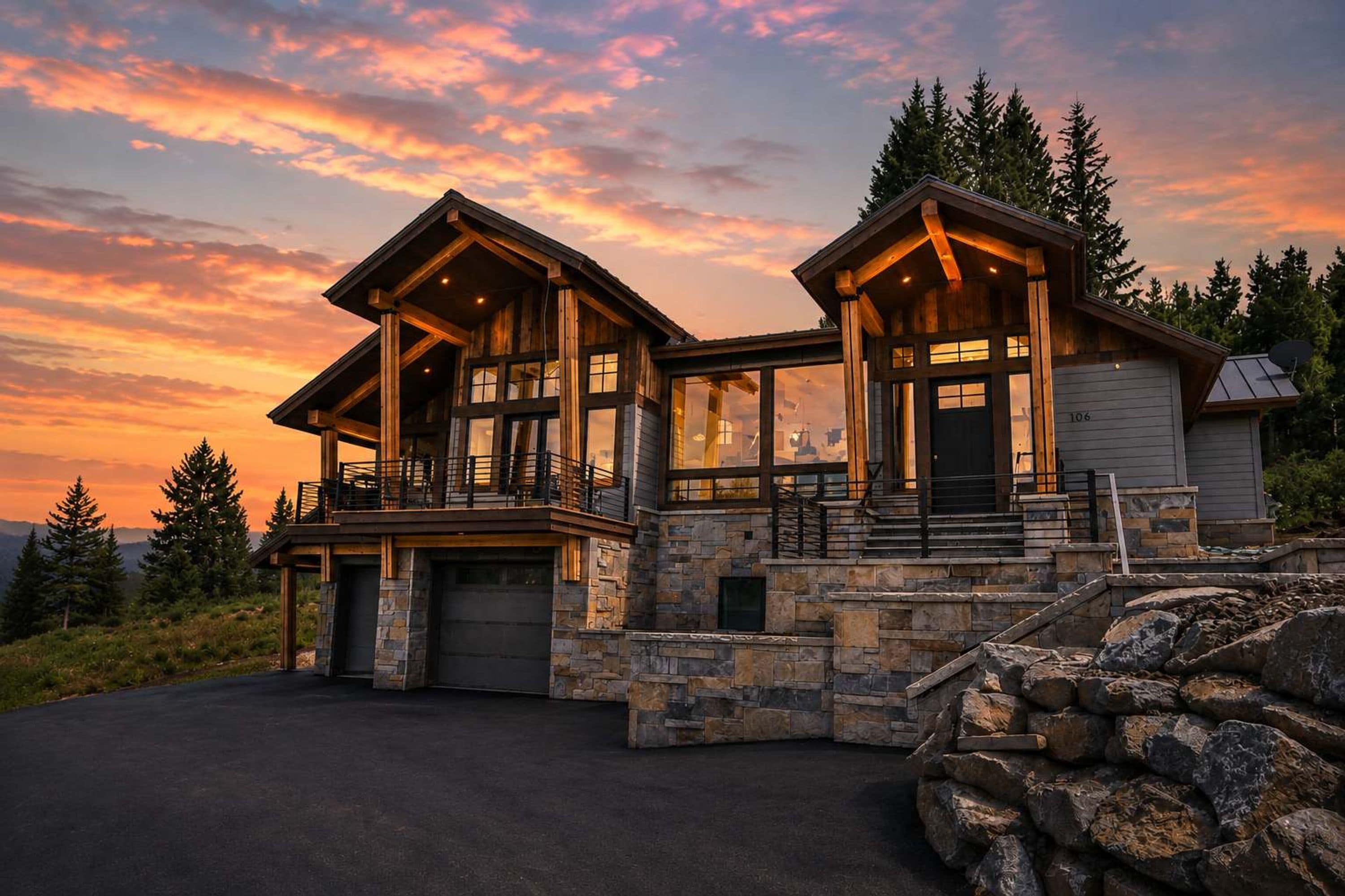 A two-story log cabin with a stone foundation and a garage.