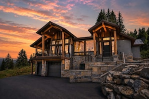 A two-story log cabin with a stone foundation and a garage. - Bear Scratch Mountain Views Modern Luxury (Crested Butte)