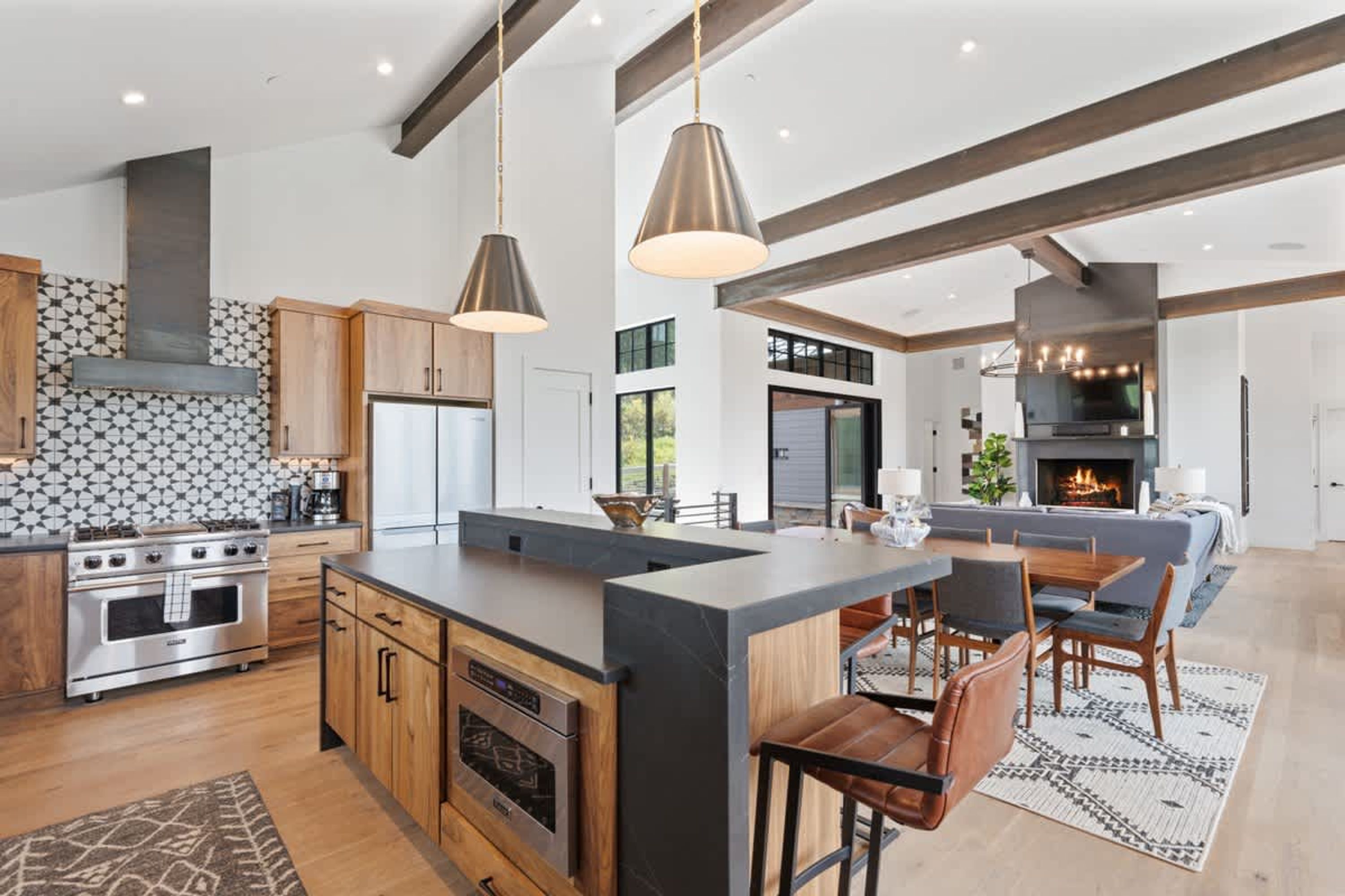 A modern kitchen with a central island, stainless steel appliances, and pendant lighting.