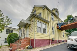 A two-story house with a red brick staircase, a garage, and a white car parked in front. - Near Shops & Transit to Nyc! Yonkers Apt (Yonkers)