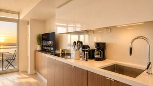 Een moderne keuken met een ingebouwde televisie, koffiezetapparaat en uitzicht op de stad.