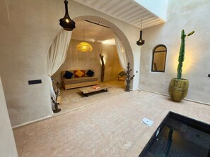 A spacious living area with a sofa, a coffee table, and a large potted plant. - The Connected Riad: Remote Work in the Sun, a Giant Rooftop, & Professional Wi-Fi (Marrakech)